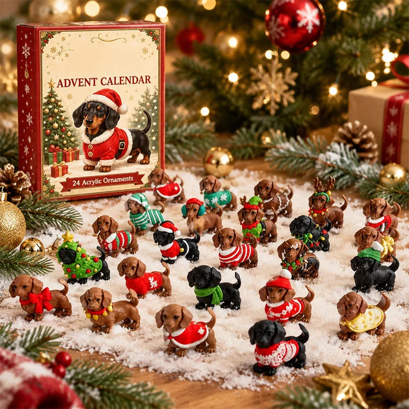 A Christmas advent calendar set displayed on a wooden surface with a box labeled 'ADVENT CALENDAR' and '24 Acrylic Ornaments.' The scene includes many small dachshund figurines wearing red, green, and white holiday sweaters, surrounded by pine branches, ornaments, and a blurred Christmas tree in the background.