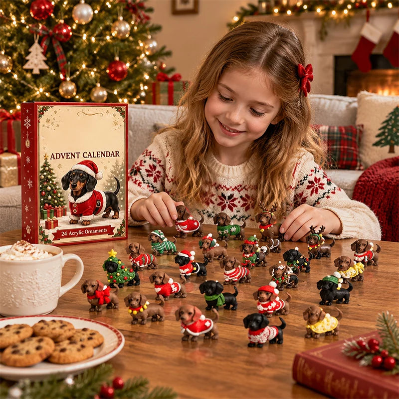 A young girl in a festive sweater smiles while arranging small dachshund Christmas ornament figurines on a wooden table. The red and gold Advent Calendar box stands beside her, with cookies, a mug of hot chocolate, and a decorated Christmas tree in the background.